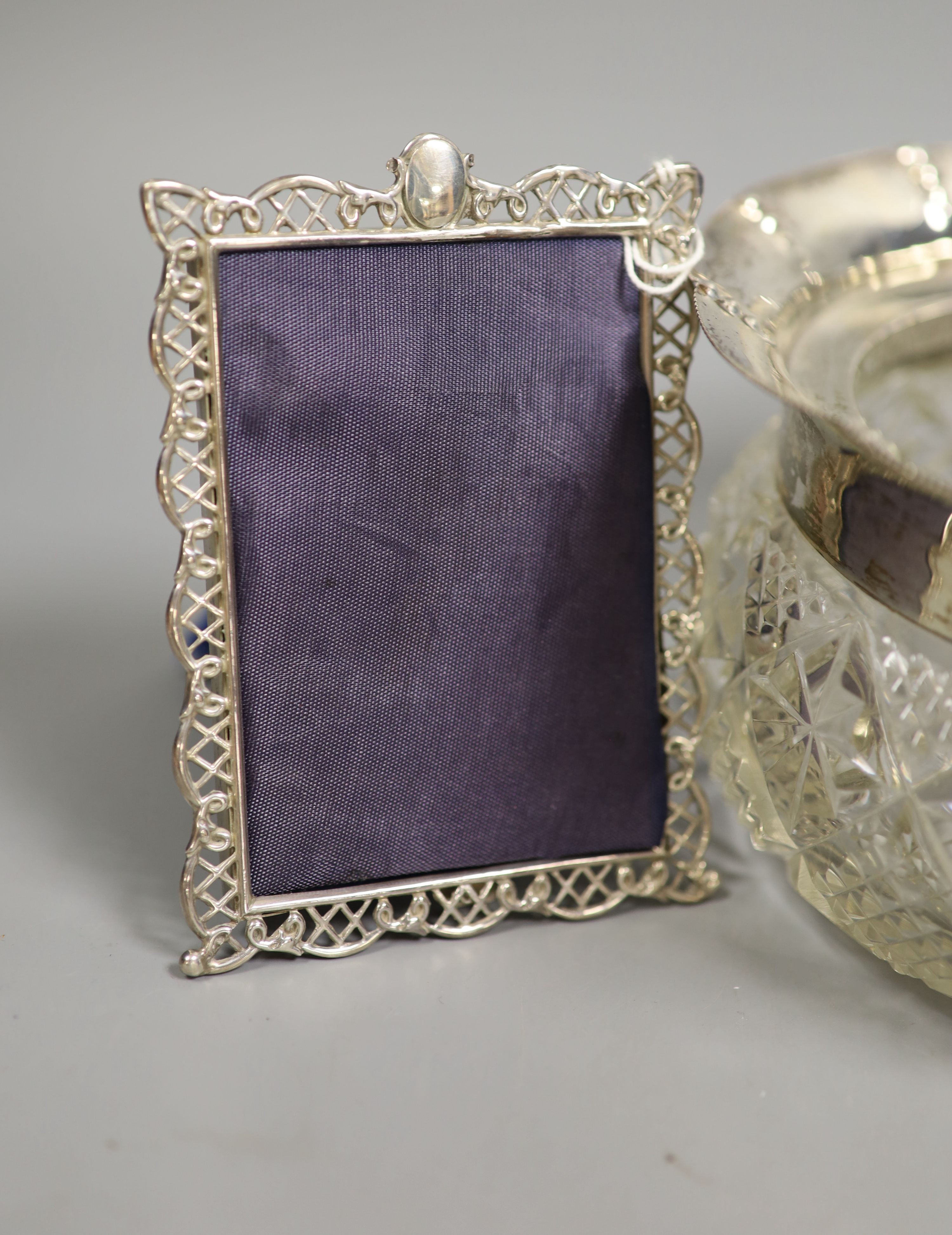 A small selection of decorative silver items to include a Georgian pierced strainer, a mustard pot, pair of sugar tongs and a mounted glass jar (lacking cover).